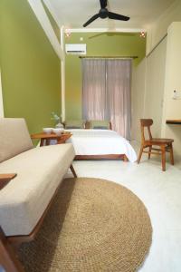 a bedroom with a bed and a couch and a fan at Nagomi Studio Nyanyi in Cemagi +32 photos