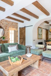 a living room with a green couch and a table at Cal Moline Arrels - Refugio rural de diseño en el Berguedà in Graugés
