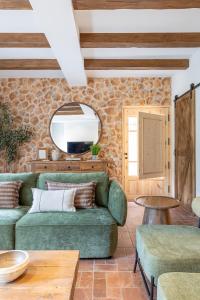 a living room with a green couch and a table at Cal Moline Arrels - Refugio rural de diseño en el Berguedà in Graugés