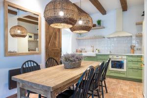 a kitchen with green cabinets and a wooden table with chairs at Cal Moline Arrels - Refugio rural de diseño en el Berguedà in Graugés