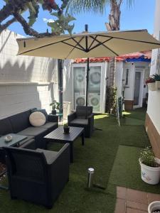 a patio with a table and an umbrella at Circus-Goretti House in Mairena del Aljarafe