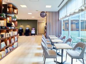 a waiting room with tables and chairs in a library at Comfort Hotel Gifu in Gifu