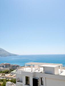 a white building with the ocean in the background at Azzurro Vista in Budva