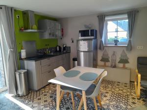 a small kitchen with a table and chairs in it at Le Cerf volant in Libin +16 photos