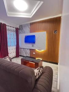 a living room with a couch and a flat screen tv at Soana in Fort Portal