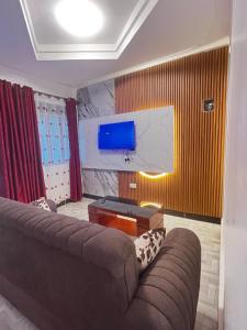 a living room with a couch and a flat screen tv at Soana in Fort Portal