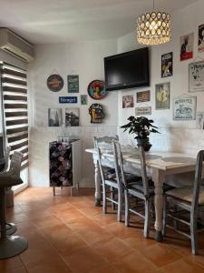 a dining room with a table and a tv on the wall at Circus-Goretti House in Mairena del Aljarafe