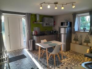 a kitchen with a table and chairs and a refrigerator at Le Cerf volant in Libin