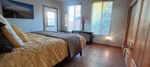 a bedroom with a bed in a room with windows at Casa Lagunita in Ensenada