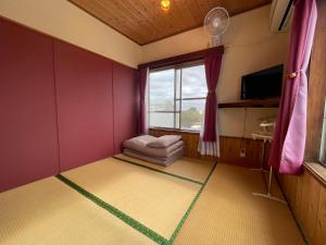 a small room with a couch and a window at 47HOSTEL in Wadomari