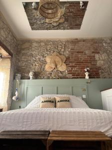 a bedroom with a bed and a brick wall at Vénusté, Suite romantique in Périgueux