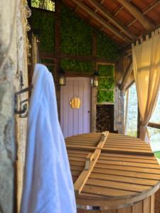 a wooden porch with a table and a purple door at Vénusté, Suite romantique in Périgueux