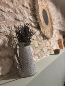 a vase with a plant in it sitting on a shelf at Vénusté, Suite romantique in Périgueux