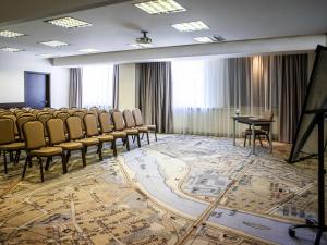 ein Konferenzraum mit Stühlen, einem Tisch und einer Bühne in der Unterkunft IBIS Styles Kaunas Centre in Kaunas