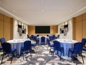 a conference room with tables and chairs and a screen at Mercure Tangerang Centre in Tangerang +53 photos