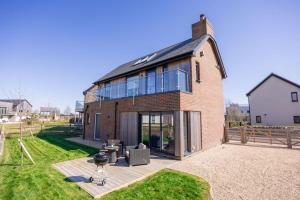 a large brick house with glass windows and a grill at Cosy Cottage in Dorchester