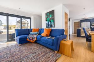 a blue couch in a living room with a table at Cosy Cottage in Dorchester