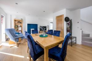 a dining room with a wooden table and blue chairs at Cosy Cottage in Dorchester
