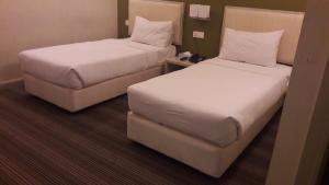 En eller flere senge i et værelse på Kosma Business Hotel