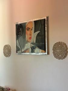 a painting of a woman with a camera on a wall at Evens-Goretti House in Mairena del Aljarafe