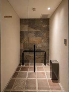 a glass shower in a room with a stone wall at KIORI Collection Gokomachi in Kyoto +76 photos
