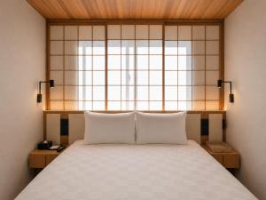 a bedroom with a large bed with a window at KIORI Collection Gokomachi in Kyoto