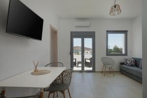 a living room with a couch and a table and chairs at Marilia Studios in Livadakia