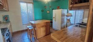 a kitchen with green walls and a white refrigerator at Casa Lagunita in Ensenada
