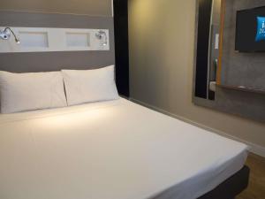 a large white bed in a hotel room at ibis budget Maceió Pajuçara in Maceió +99 photos