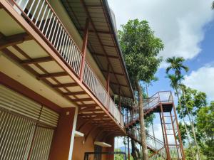 a building with a balcony and a tree at VARIYATH HOMESTAY THIRUNELLi in Thirunelli