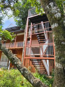 an orange building with a staircase in front of it at VARIYATH HOMESTAY THIRUNELLi in Thirunelli