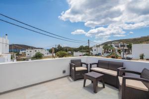 a patio with chairs and tables on a balcony at Marilia Studios in Livadakia