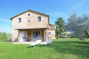 a house with two white chairs in the yard at Fontesecca - Happy Rentals in Città della Pieve