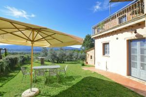 a patio with a table and chairs and an umbrella at Fontesecca - Happy Rentals in Città della Pieve