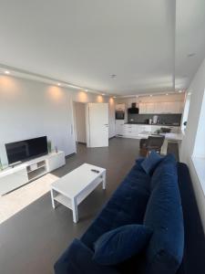 a living room with a blue couch and a white table at Modern new-build apartment in Groß-Gerau