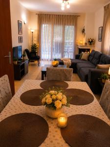 a living room with a table with flowers on it at Keramoti Luxury Apartments in Keramoti