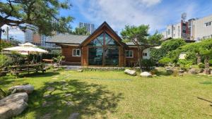 a small wooden house with a grass yard at 경상북도 감성숙소 청화소담 in Yeongcheon