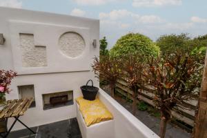 a balcony with a table and a bench and trees at Penvar in Truro