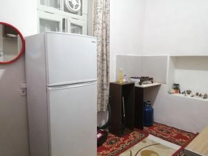 a kitchen with a white refrigerator in a room at Courtyard Cottage in Athens