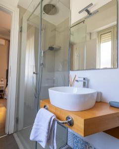 a bathroom with a white sink and a shower at Athena Charming Rooms in Taormina