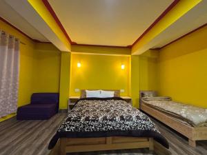 a yellow room with a bed and a chair at Hotel Sonam Chen Residency Lachung in Lachung +5 photos