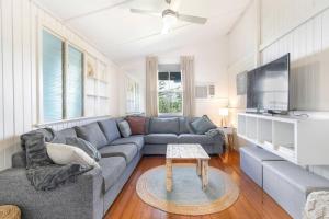 a living room with a couch and a tv at 30A Urangan Beach Cottage (Front Property) in Urangan