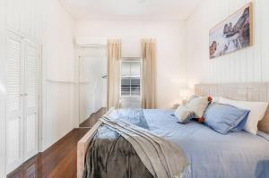 a bedroom with a bed with a teddy bear on it at 30A Urangan Beach Cottage (Front Property) in Urangan