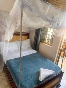 a bedroom with a bed with a canopy at Zone hotel and guest house in Bugembe