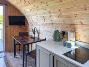 a kitchen with a table and a tv in a cabin at Oak - Uk51863 in Reighton