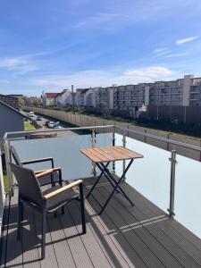 a table and a chair on a balcony with a river at Modern new-build apartment in Groß-Gerau