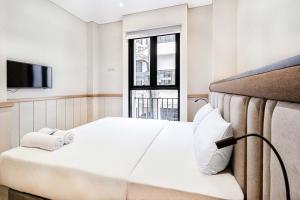 a hotel room with a bed and a window at Rucio Kostel Semarang in Jatingaleh