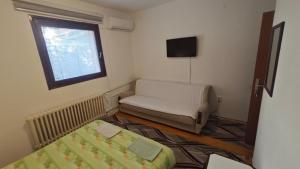 a room with a bed and a couch and a window at Prenoćište Dika in Višegrad +7 photos