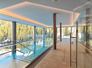 a house with a swimming pool on a balcony at Hotel Zirbenhof in Hochfugen