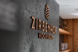 a sign on the side of a concrete pillar at Hotel Zirbenhof in Hochfugen